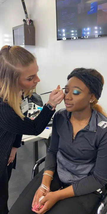 Dailin applying blue eyeshadow on a client at Paul Mitchell The School